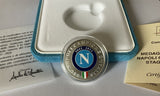 Napoli Scudetto medal held to show scale