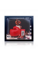 Framed red leather boxing glove signed by Muhammad Ali displayed on a wall
