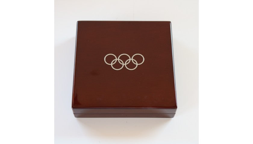 IOC 125th anniversary medal shown alongside both Swatch watches