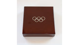 IOC 125th anniversary medal shown alongside both Swatch watches