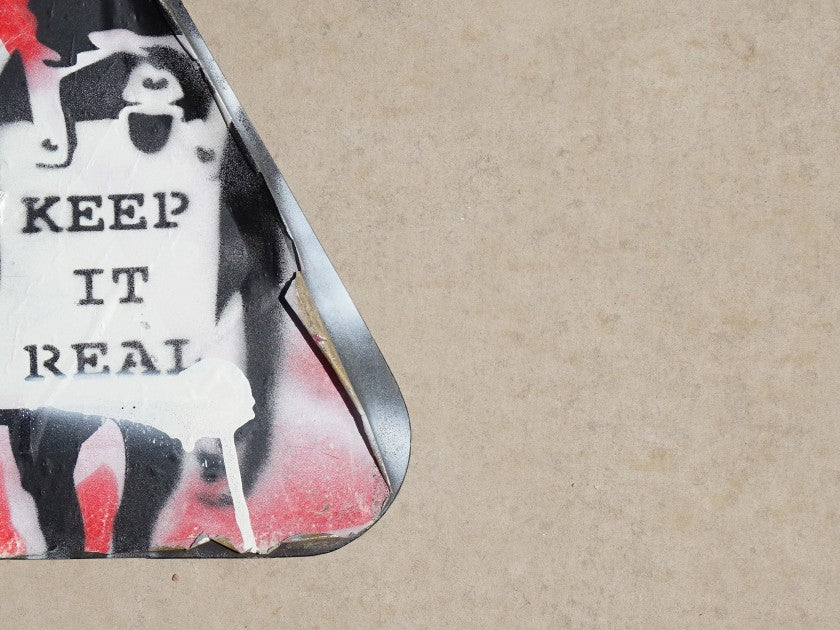 Detail of spray paint and print technique on the Banksy-attributed road sign